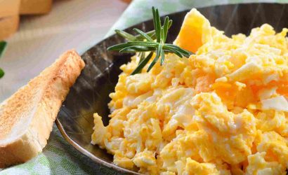 Scrambled eggs served in a pan with toast